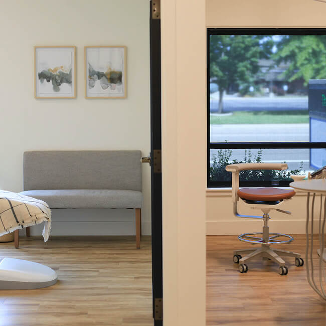 Thin wall dividing two treatment rooms with chairs in them