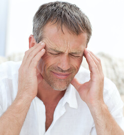 Man having a headache and holding his temples